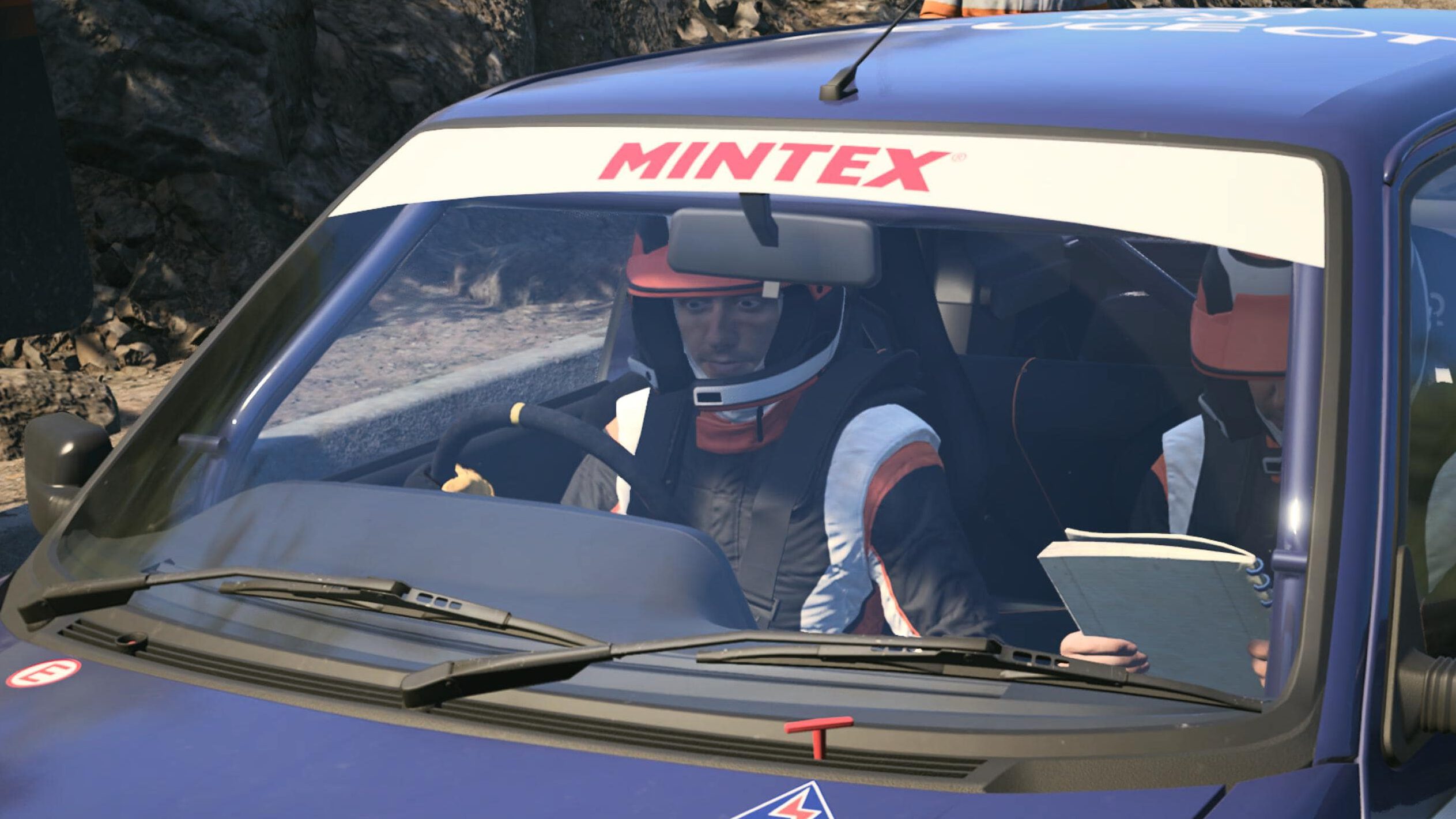 Closeup auf die beiden Fahrer. Der Fahrer am Steuer reißt die Augen weit auf.